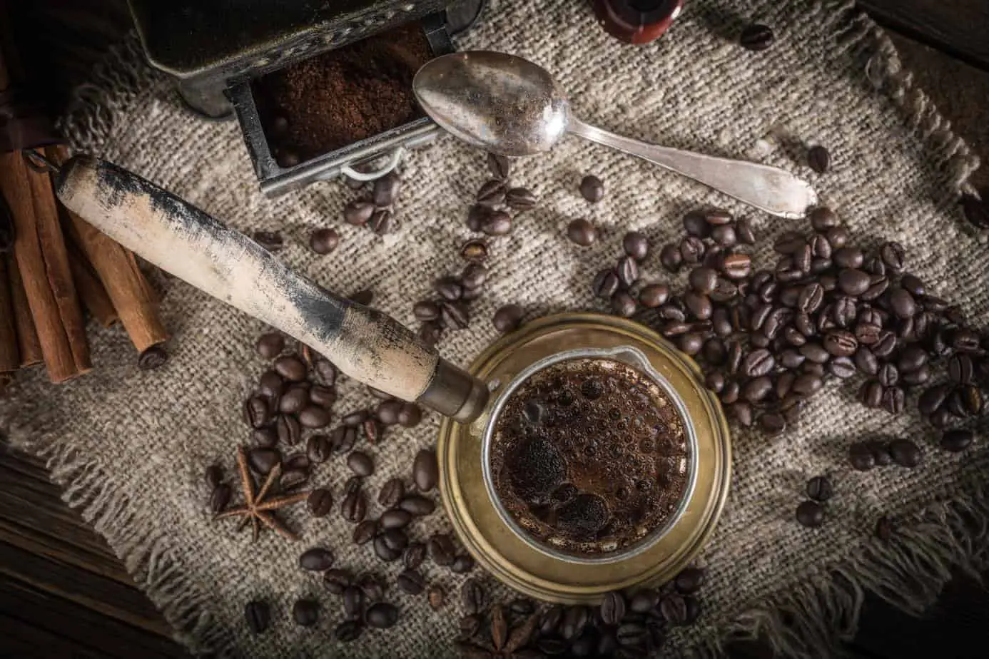 حبوب البن العربية والتوابل على طاولة خشبية تعرض ثقافة القهوة العربية.