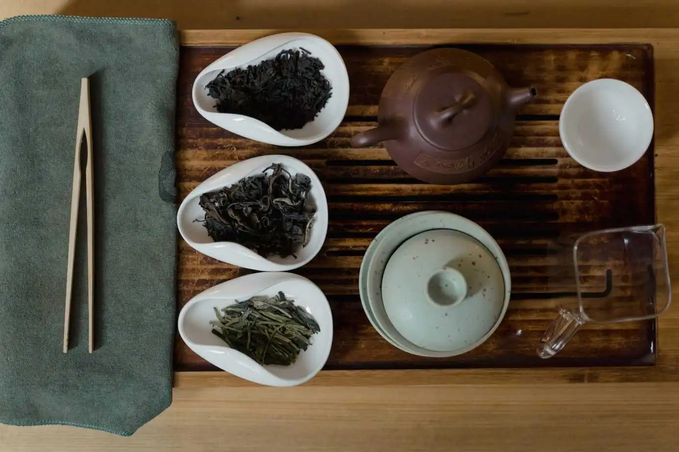 صينية بها أوعية شاي وأنواع مختلفة من الشاي عليها.
