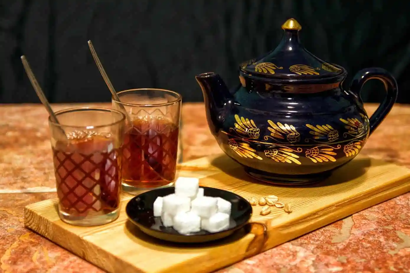 كوبان من الشاي الأسود على صينية خشبية يعرضان فوائد الشاي الأسود.